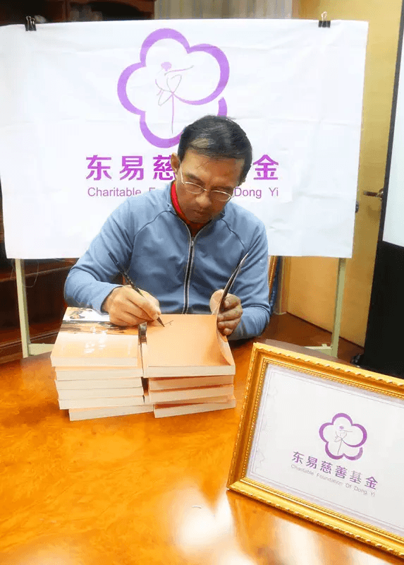 主持人王志为“第二届东易慈善中国行”活动签书留念（图片2）
