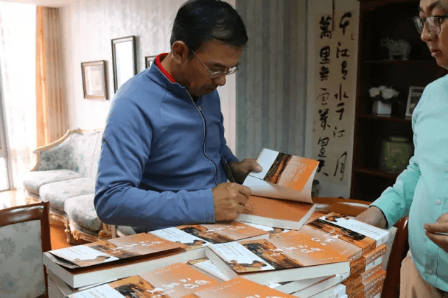 主持人王志为“第二届东易慈善中国行”活动签书留念（图片6）