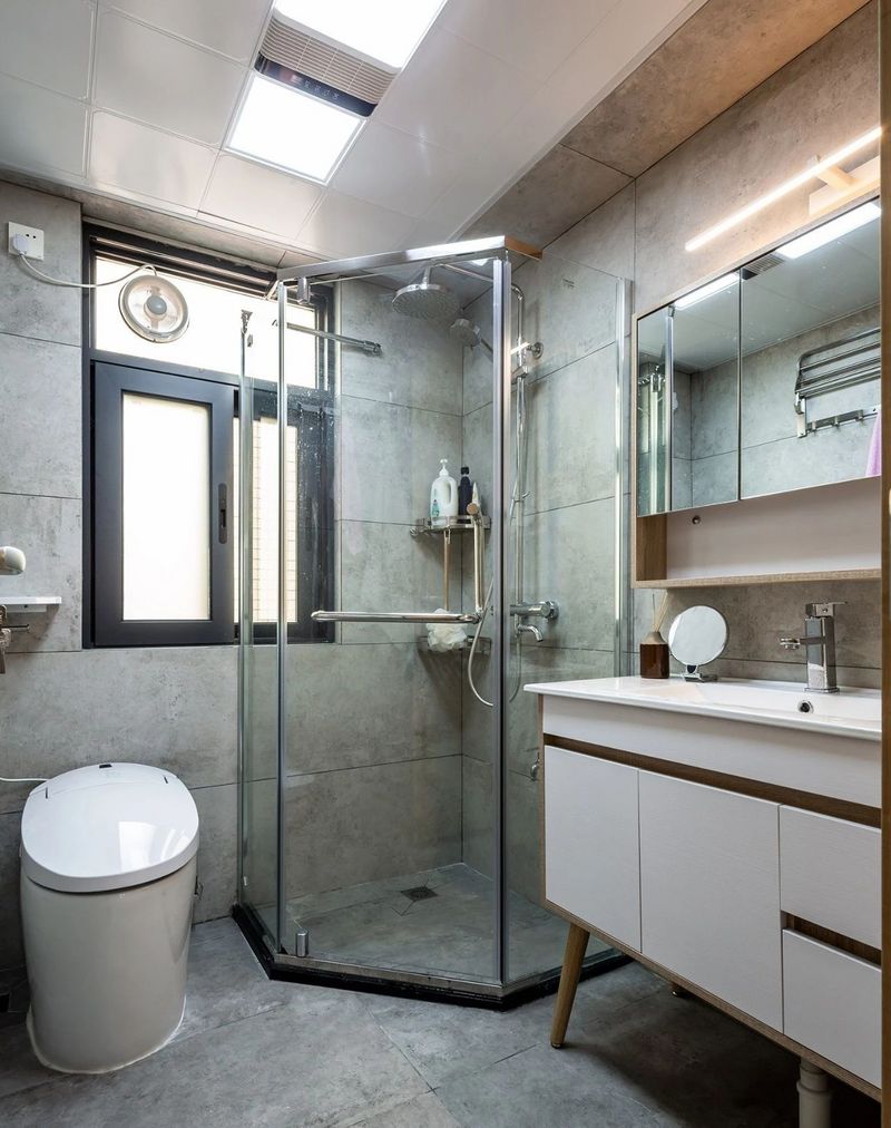 卫生间,墙地面通铺灰色石纹砖,成品浴室柜与半开放式镜柜解放台面空间