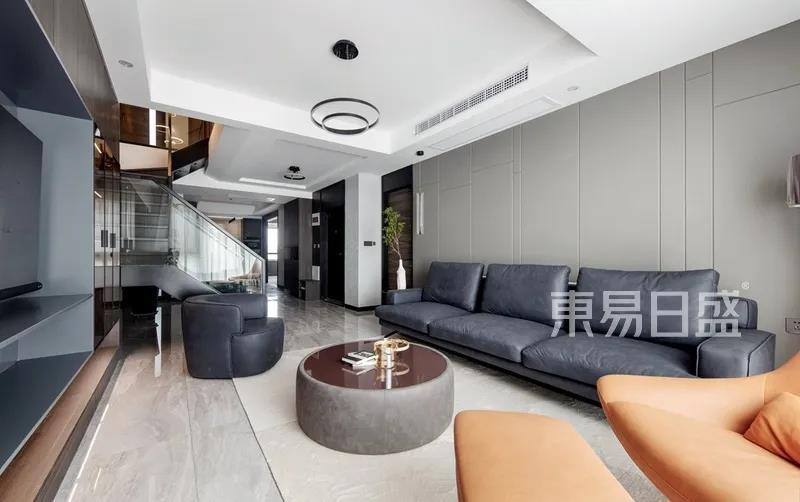 客厅-灰色的布艺沙发搭配奶白色的地毯 ，丰富了空间，一抹爱马仕橙的加入，提高了客厅的时尚感。.jpg